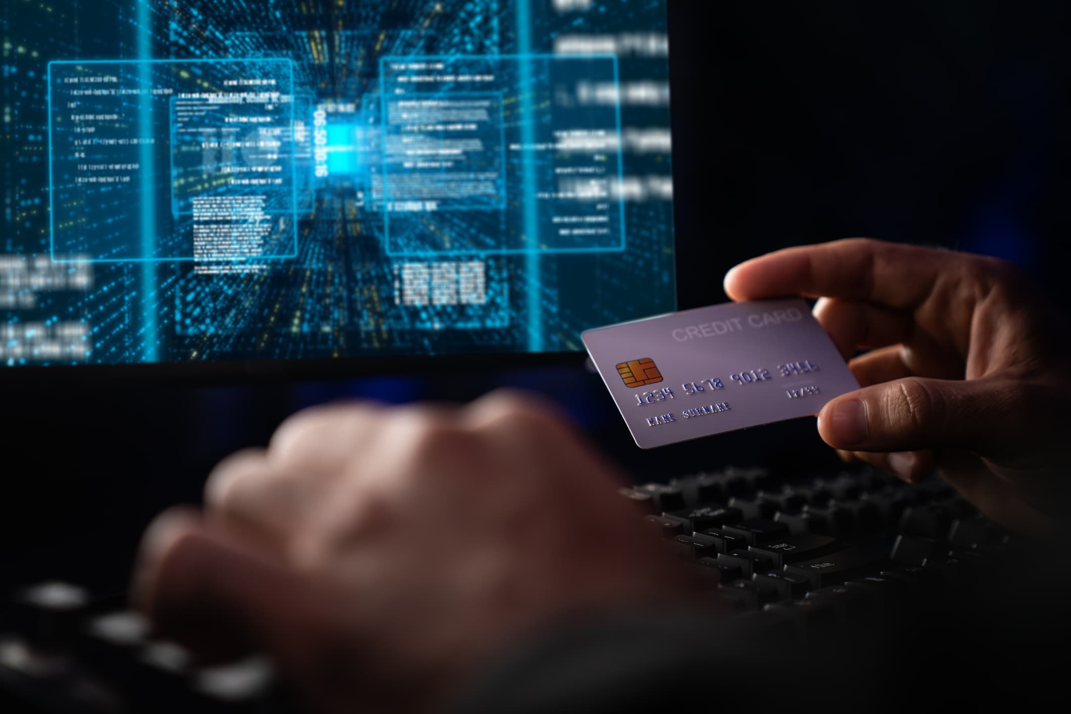 Hacker at a computer with a credit card fraud